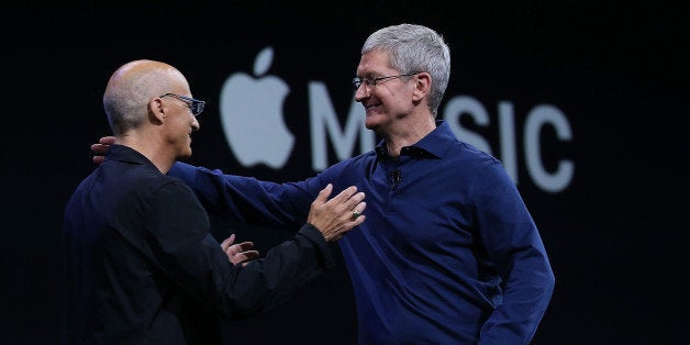 SAN FRANCISCO, CA - JUNE 08: Apple CEO Tim Cook (R) greets Johnny Iovine during the keynote address during Apple WWDC on June 8, 2015 in San Francisco, California. Apple's annual developers conference runs through June 12. (Photo by Justin Sullivan/Getty Images)