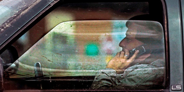 A driver talks on the phone on Tuesday, April 2, 2013 in Montpelier, Vt. Vermont lawmakers are continuing their efforts to crack down on distracted driving, with bills that would boost the penalties for texting while driving and ban all hand-held electronic devices when driving through road construction zones. Two House committees are studying those measures, while prospects for a proposed outright ban on using portable electronic devices while driving appear slim. Vermonters already are banned from texting while driving and drivers under 18 are barred from using any portable electronic device. (AP Photo/Toby Talbot)