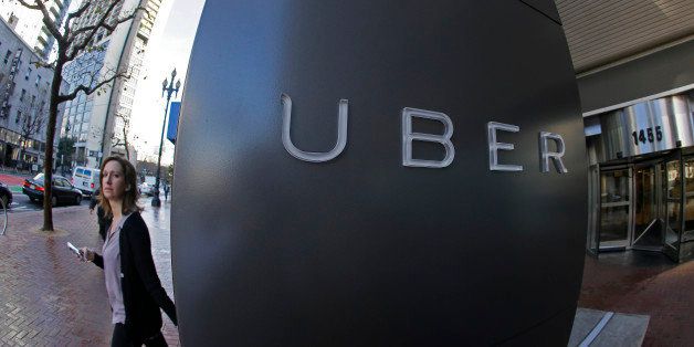 In this photo taken Tuesday, Dec. 16, 2014, a woman leaves the headquarters of Uber in San Francisco. (AP Photo/Eric Risberg)