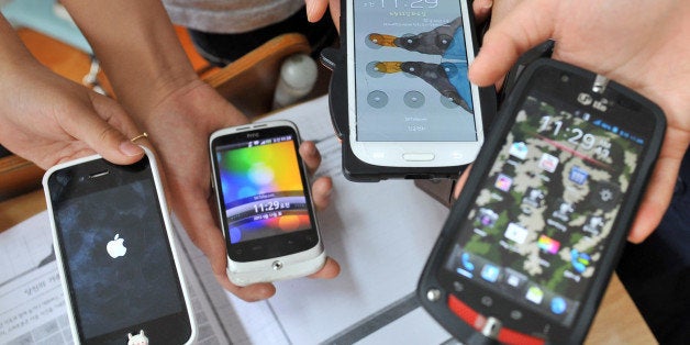 TO GO WITH AFP STORY SKorea-technology-IT-addiction-health,FEATURE by JUNG Ha-WonThis picture taken on June 11, 2013 shows South Korean children displaying their smartphones after a special class on smartphone addiction at an elementary school in Seongnam, south of Seoul. South Korea, after boasting for years advanced technology from high-speed Internet to Samsung smartphones, is now taking pains to try to pull its tech-crazed youth away from digital addiction. AFP PHOTO / JUNG YEON-JE (Photo credit should read JUNG YEON-JE/AFP/Getty Images)