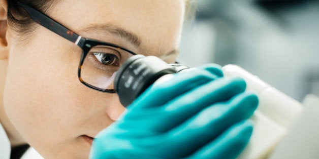 Close up shot of a female scientist through a microscope