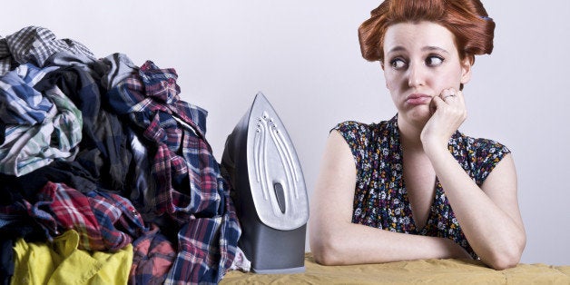 housewife with hair curlers bored with ironing