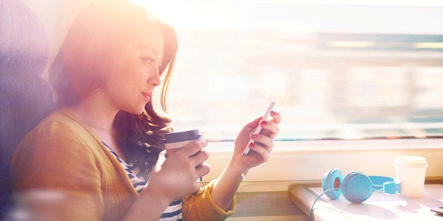 Woman on a commuter train looking at her phone.