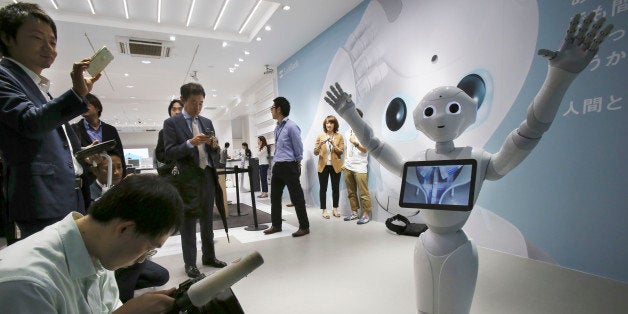 FILE - In this June 6, 2014 file photo, journalists surround humanoid robot Pepper on display at SoftBank Mobile shop in Toky