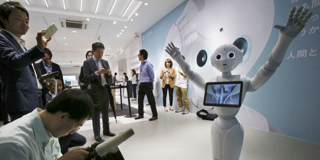 FILE - In this June 6, 2014 file photo, journalists surround humanoid robot Pepper on display at SoftBank Mobile shop in Tokyo. Japanese mobile carrier Softbank said Tuesday, Feb. 10, 2015 it will incorporate artificial intelligence technology from IBM into its empathetic robot Pepper that goes on sale in Japan this month. (AP Photo/Koji Sasahara, File)