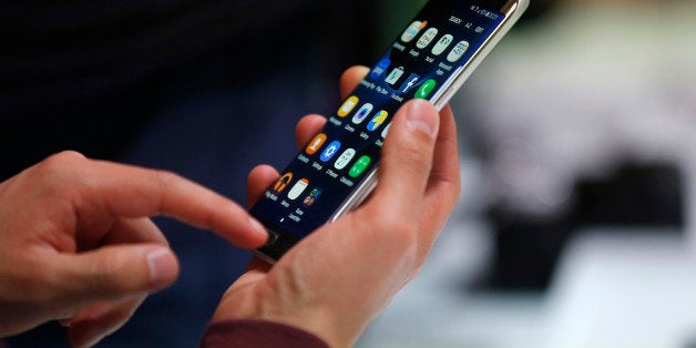 A man holds the Samsung Galaxy S7 Edge during the Samsung Galaxy Unpacked 2016 event on the eve of this weekâs Mobile World Congress wireless show, in Barcelona, Spain, Sunday, Feb. 21, 2016. (AP Photo/Manu Fernadez)