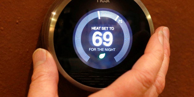 PROVO, UT - JANUARY 16: In this photo illustration, a Nest thermostat is being adjusted in a home on January 16, 2014 in Provo, Utah. Google bought Nest, a home automation company, for $3.2 billion taking Google further into the home ecosystem. (Photo illustration by George Frey/Getty Images)