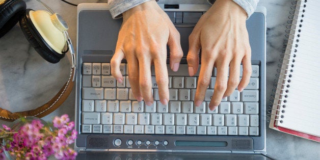 Mixed race woman using laptop at table