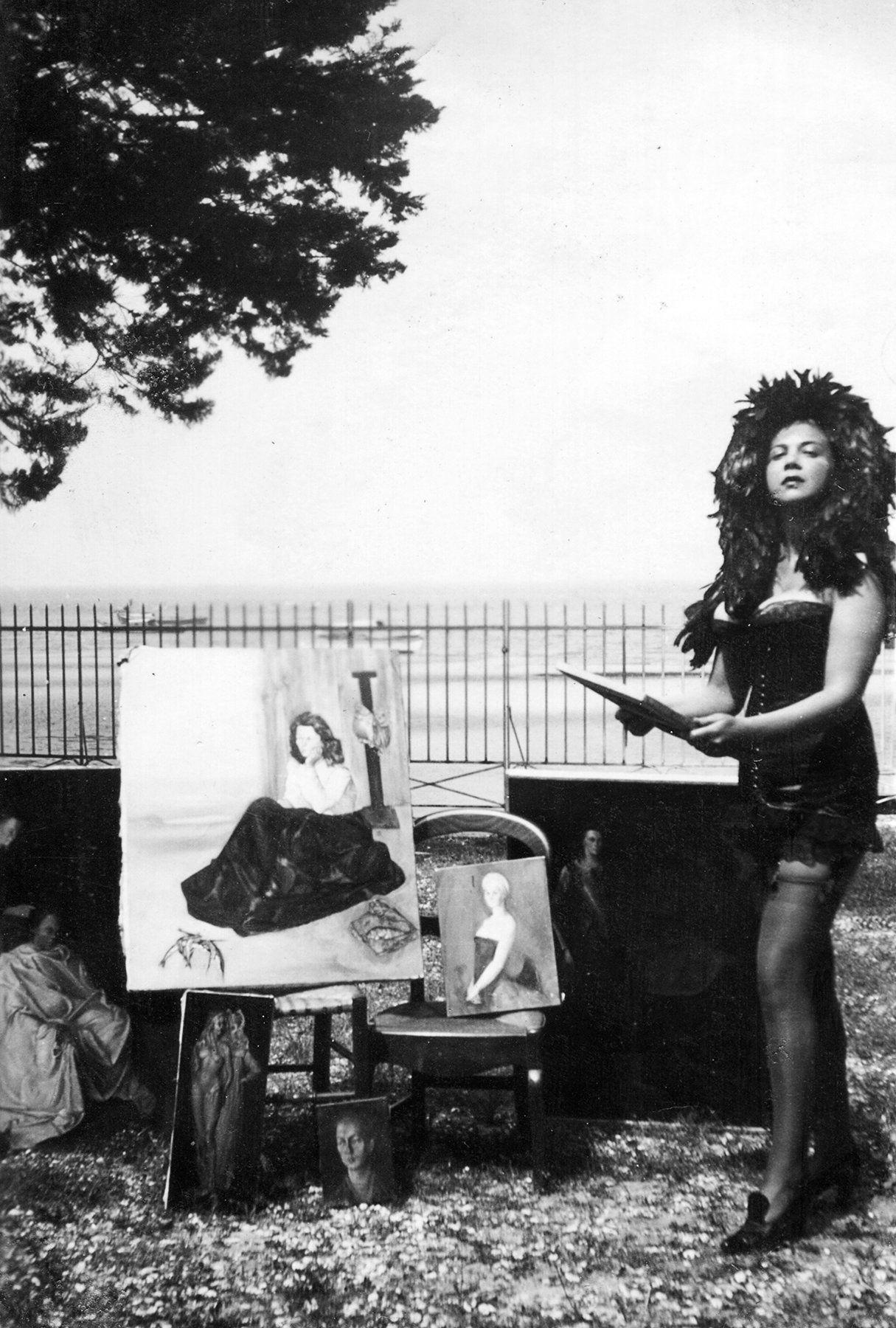 Leonor Fini painting in a feather headdress.