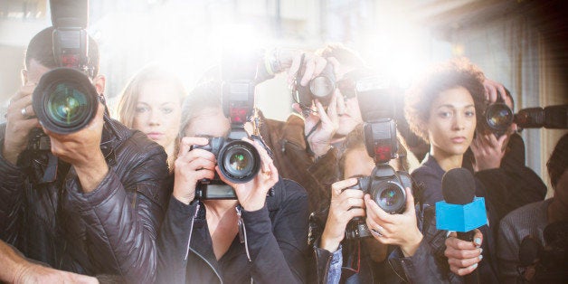 Portrait of serious paparazzi photographers pointing cameras