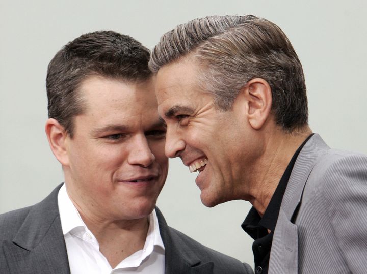 Hollywood, UNITED STATES: Actors Matt Damon (L) and George Clooney share a joke after immortalizing their prints in cement in the famed forecourt of Grauman?s Chinese Theatre in celebration of their new movie, ?Ocean?s Thirteen', 05 June 2007 in Hollywood, California. AFP PHOTO GABRIEL BOUYS (Photo credit should read GABRIEL BOUYS/AFP/Getty Images)