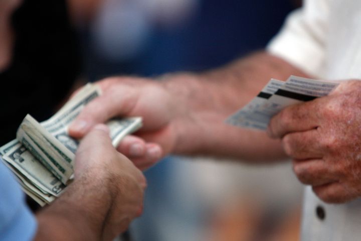 ST PETERSBURG, FL - OCTOBER 22: A fan holds tickets and another holds money before the Philadelphia Phillies take on the Tampa Bay Rays during game one of the 2008 MLB World Series on October 22, 2008 at Tropicana Field in St. Petersburg, Florida. (Photo by Jamie Squire/Getty Images)