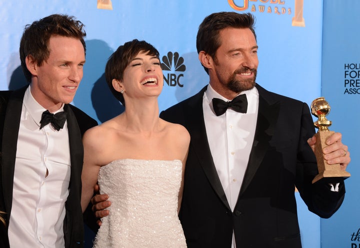 From left: Eddie Redmayne, Anne Hathaway and Hugh Jackman pose with the best motion picture comedy or musical award for 'Les Miserables' in the press room at the Golden Globes awards ceremony in Beverly Hills on January 13, 2013. AFP PHOTO/Robyn BECK (Photo credit should read ROBYN BECK/AFP/Getty Images)