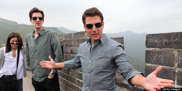 American actor and producer Tom Cruise (R) gestures as he visits the Mutianyu Great Wall in Beijing on May 9, 2013. His new movie 'Oblivion' would be released in China on May 10, state media reported. CHINA OUT AFP PHOTO (Photo credit should read STR/AFP/Getty Images)