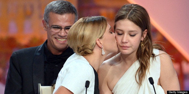 French actress Lea Seydoux (L) kisses on May 26, 2013 fellow actress Adele Exarchopoulos after French-Tunisian director Abdellatif Kechiche (C) won the Palme d'Or for the film 'Blue is the Warmest Colour' during the closing ceremony of the 66th Cannes film festival in Cannes. AFP PHOTO / ALBERTO PIZZOLI (Photo credit should read ALBERTO PIZZOLI/AFP/Getty Images)