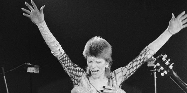 David Bowie in concert, circa 1973. He is wearing a mesh outfit with fake hands holding his chest. (Photo by Terry O'Neill/Hulton Archive/Getty Images)
