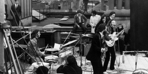 30th January 1969: British rock group the Beatles performing their last live public concert on the rooftop of the Apple Organization building for director Michael Lindsey-Hogg's film documentary, 'Let It Be,' on Savile Row, London, England. Drummer Ringo Starr sits behind his kit. Singer/songwriters Paul McCartney and John Lennon perform at their microphones, and guitarist George Harrison (1943 - 2001) stands behind them. Lennon's wife Yoko Ono sits at right. (Photo by Express/Express/Getty Images)