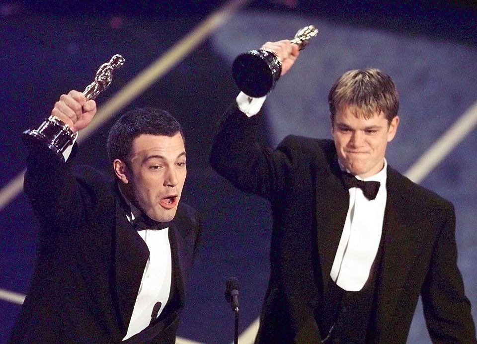 Ben Affleck (L) and Matt Damon hold up their Oscar