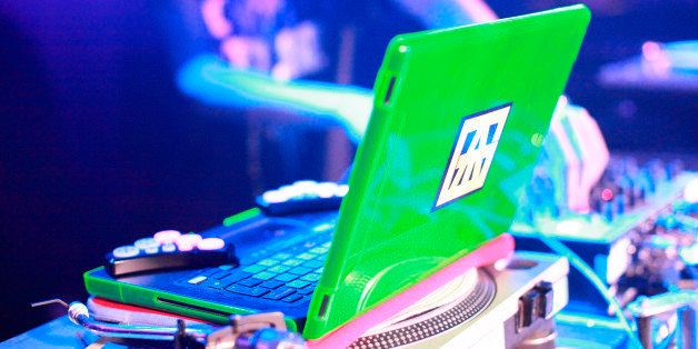 A fluorescent laptop sits on top of a set of turn tables and is being used to mix tunes by DJ Klose One. The ATG sticker on the back represents a famous London graffiti crew. The Garage in North London, 2011. (Photo by: PYMCA/UIG via Getty Images)