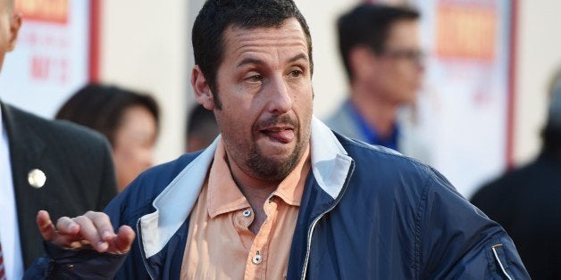 Actor Adam Sandler makes a silly face for photographers as he arrives for the red carpet premiere of 'Blended,' May 21, 2014 at TCL Chinese Theatre in Hollywood, California. AFP PHOTO / ROBYN BECK (Photo credit should read ROBYN BECK/AFP/Getty Images)