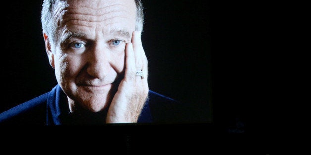 LOS ANGELES, CA - AUGUST 25: 66th ANNUAL PRIMETIME EMMY AWARDS -- Pictured: (l-r) An image of the late Robin Williams appears while actor/comedian Billy Crystal speaks on stage during the 66th Annual Primetime Emmy Awards held at the Nokia Theater on August 25, 2014. (Photo by Mark Davis/NBC/NBC via Getty Images)