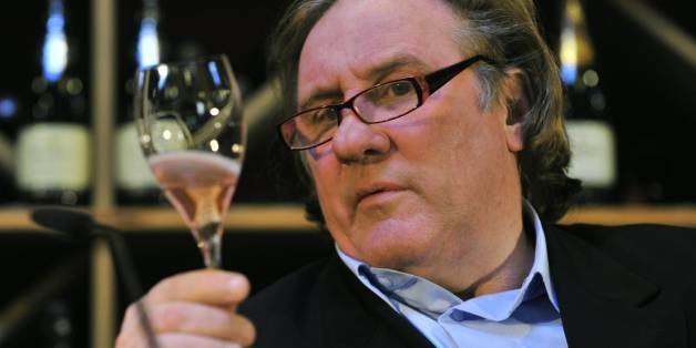 French actor Gerard Depardieu holds up a sample of his sparkling rose wine during a wine presentation in a Berlin wine shop November 30, 2010. Depardieu presented his 'Taille Princesse' Brut, by Bouvet-Laduray, which the actor helped elaborate. AFP PHOTO / JOHN MACDOUGALL (Photo credit should read JOHN MACDOUGALL/AFP/Getty Images)