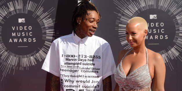 Model Amber Rose (R) and rapper Wiz Khalifa (L) arrive on the red carpet at the MTV Video Music Awards (VMA), August 24, 2014 at The Forum in Inglewood, California. AFP PHOTO / Mark Ralston (Photo credit should read MARK RALSTON/AFP/Getty Images)