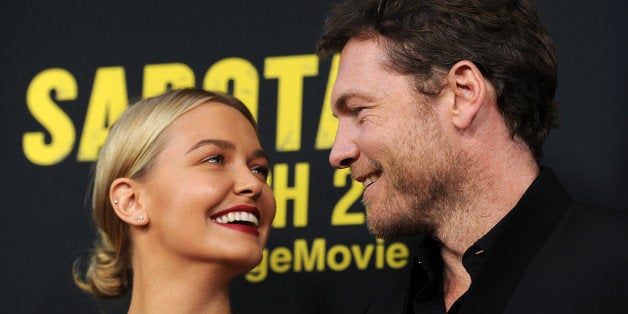 Sam Worthington, a cast member in "Sabotage," poses with his girlfriend Lara Bingle at the premiere of the film on Wednesday, March 19, 2014 in Los Angeles. (Photo by Chris Pizzello/Invision/AP)