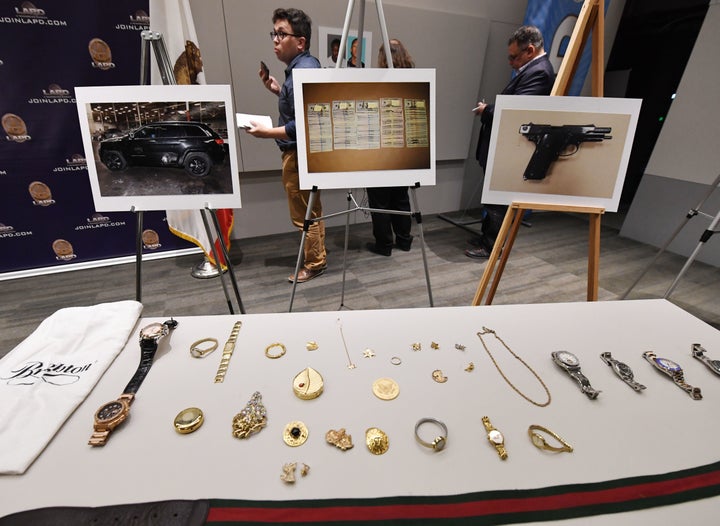 Police displayed seized items believed to have been stolen — including expensive purses, handbags, watches and jewelry
