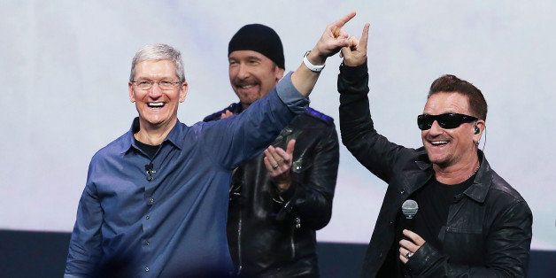 CUPERTINO, CA - SEPTEMBER 09: Apple CEO Tim Cook (L) greets the crowd with U2 singer Bono (R) as The Edge looks on during an Apple special event at the Flint Center for the Performing Arts on September 9, 2014 in Cupertino, California. Apple unveiled the Apple Watch wearable tech and two new iPhones, the iPhone 6 and iPhone 6 Plus. (Photo by Justin Sullivan/Getty Images)