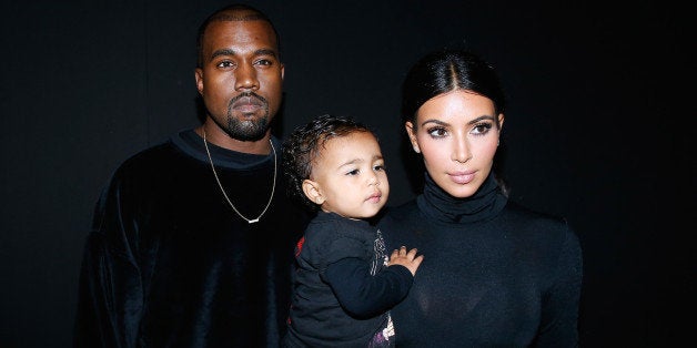 PARIS, FRANCE - SEPTEMBER 24: Kanye West, Kim Kardashian and their daughter North West attend the Balenciaga show as part of the Paris Fashion Week Womenswear Spring/Summer 2015 on September 24, 2014 in Paris, France. (Photo by Bertrand Rindoff Petroff/French Select/Getty Images)