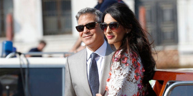 George Clooney is flanked by his wife Amal Alamuddin as they leave the Aman luxury Hotel in Venice, Italy, Sunday, Sept. 28,