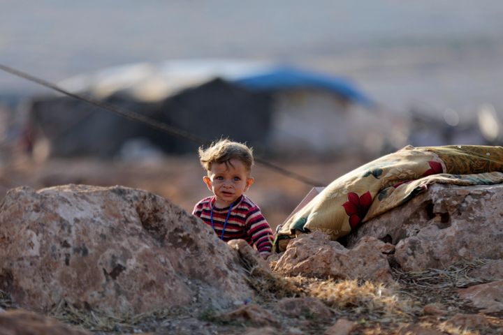 A newly displaced Syrian child walks near a refugee camp 
