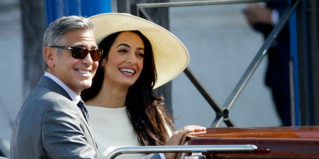 George Clooney and Amal Alamuddin leave Venice's city hall, Italy, Monday, Sept. 29, 2014. Clooney and Amal married Saturday, Sept. 27, the actor's representative said, out of sight of pursuing paparazzi and adoring crowds. (AP Photo/Andrew Medichini)