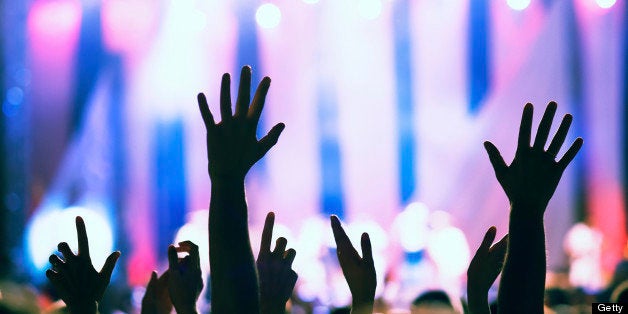 Crowd cheering and watching a band on stage, shallow DOF.