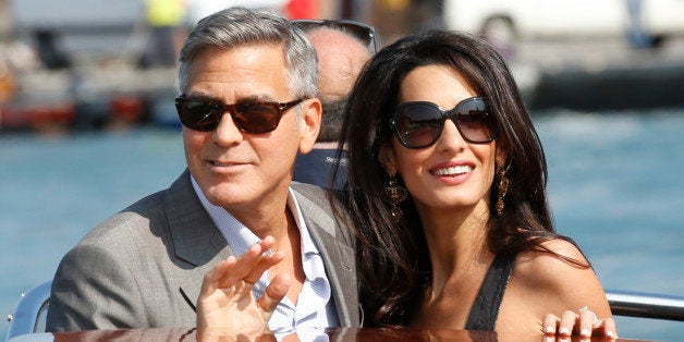 George Clooney, left, and Amal Alamuddin arrive in Venice, Italy, Friday, Sept. 26, 2014. Clooney, 53, and Alamuddin, 36, are expected to get married this weekend in Venice, one of the worldâs most romantic settings. (AP Photo/Luca Bruno)