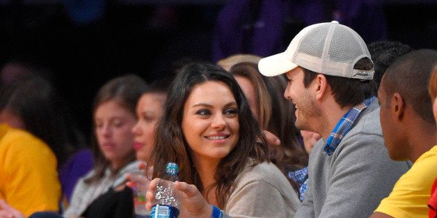 Actors Mila Kunis, left, and Ashton Kutcher watch the Los Angeles Lakers play the Oklahoma City Thunder in an NBA basketball game, Friday, Dec. 19, 2014, in Los Angeles. (AP Photo/Mark J. Terrill)