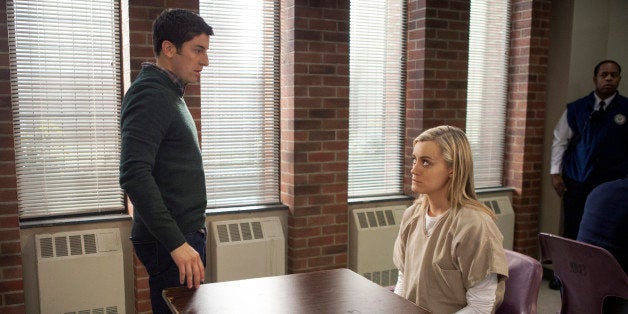 This image released by Netflix shows Jason Biggs, left, and Taylor Schilling in a scene from âOrange is the New Black.â T