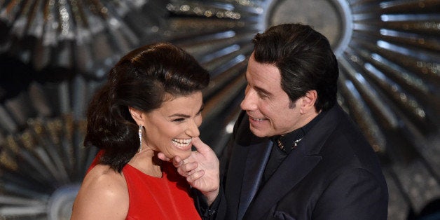 Idina Menzel, left, and John Travolta present the award for best original song at the Oscars on Sunday, Feb. 22, 2015, at the Dolby Theatre in Los Angeles. (Photo by John Shearer/Invision/AP)