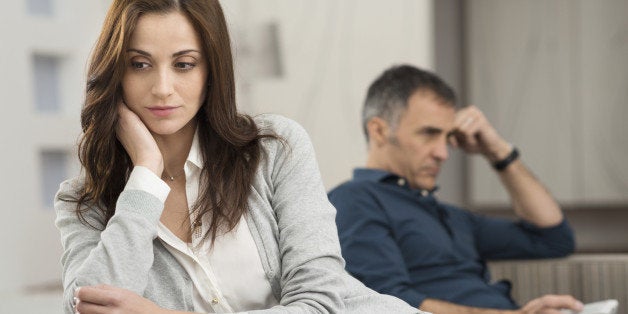 Sad Couple Sitting On Couch After Having Quarrel