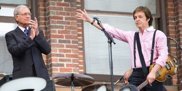 David Letterman, left, applauds musician Paul McCartney after his performance atop the Ed Sullivan Theater marquee during a t
