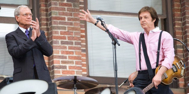 David Letterman, left, applauds musician Paul McCartney after his performance atop the Ed Sullivan Theater marquee during a taping of "The Late Show with David Letterman" in New York, Wednesday, July 15, 2009. (AP Photo/Charles Sykes)