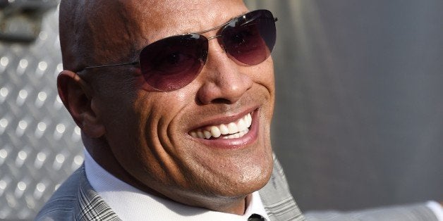 Actor Dwayne Johnson arrives on a Los Angeles Fire Department fire truck for the premiere of Warner Bros Pictures' film San Andreas, May 26, 2015 at TCL Chinese Theater in Hollywood , California. AFP PHOTO / ROBYN BECK (Photo credit should read ROBYN BECK/AFP/Getty Images)