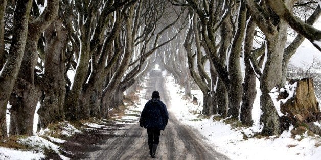 A man walks during snow along the Dark Hedges tree tunnel, which was featured in the TV series Game of Thrones, near Ballymon