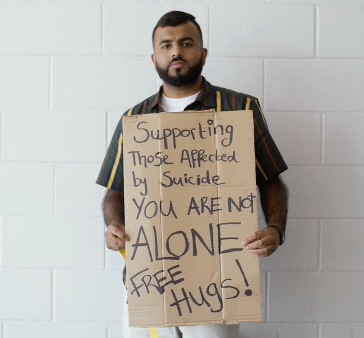 Manawer holds a sign in support of those affected by suicide.