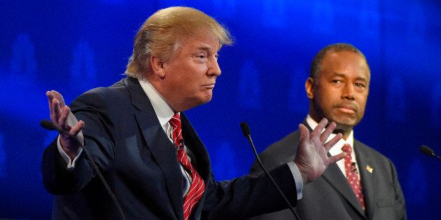 Ben Carson, right, watches as Donald Trump speaks during the CNBC Republican presidential debate at the University of Colorado, Wednesday, Oct. 28, 2015, in Boulder, Colo. (AP Photo/Mark J. Terrill)