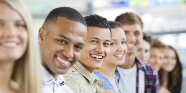 Smiling college students in a row in classroom