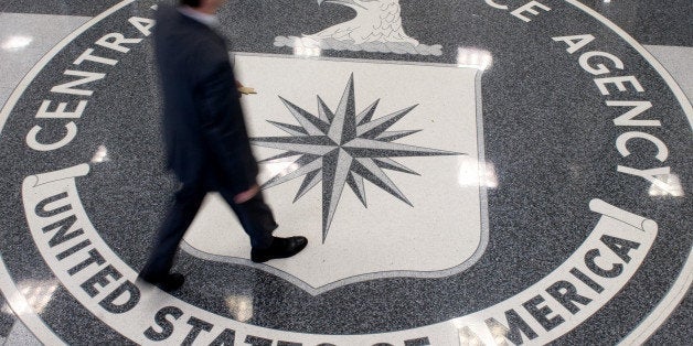 A man crosses the Central Intelligence Agency (CIA) logo in the lobby of CIA Headquarters in Langley, Virginia, on August 14,