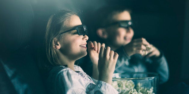 boy and girl wearing 3D glasses watching movie in home theater