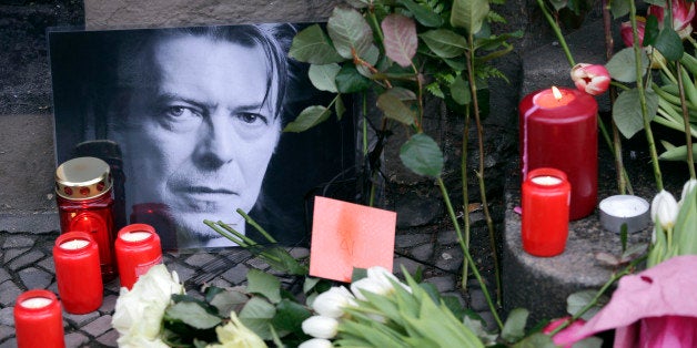 Flowers and a portrait are placed in front of the apartment building where David Bowie once lived in Berlin, Germany, Monday,